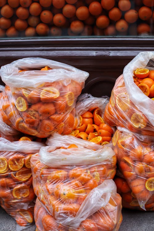 Orange Fruits and Peels in Plastic Bags