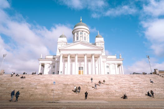 A wide-angle shot of Helsinki Cathedral featuring steps and people on a sunny day.
