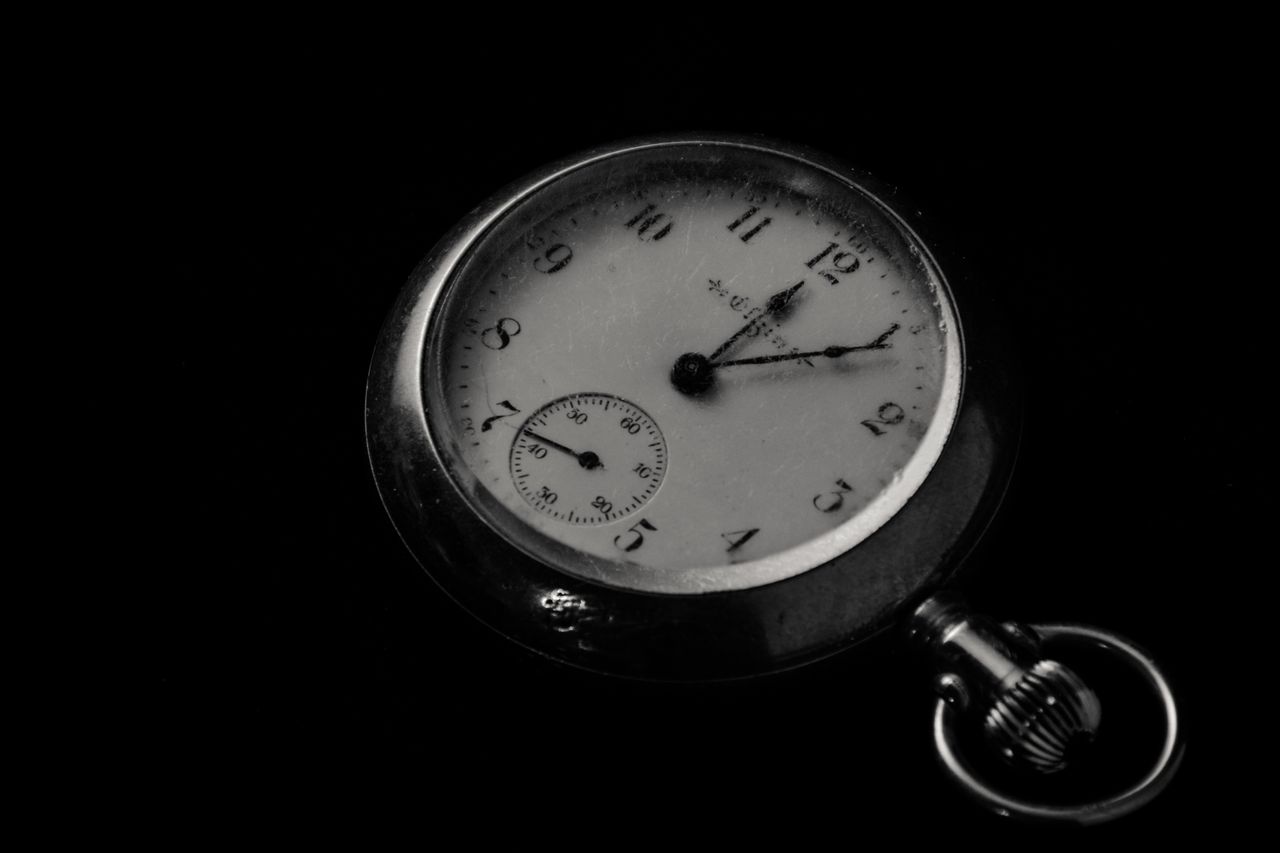 close up of a classic vintage pocket watch showing time in a dark sett