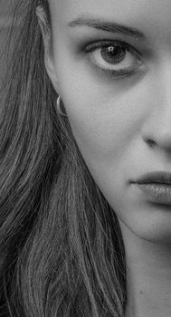 Dramatic grayscale portrait of a woman emphasizing natural beauty and emotion.