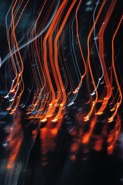 Dynamic abstract light trails against a dark city backdrop, creating a vibrant urban atmosphere.