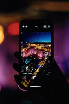 Night view of Las Vegas skyline captured through a smartphone, highlighting urban vibrancy.