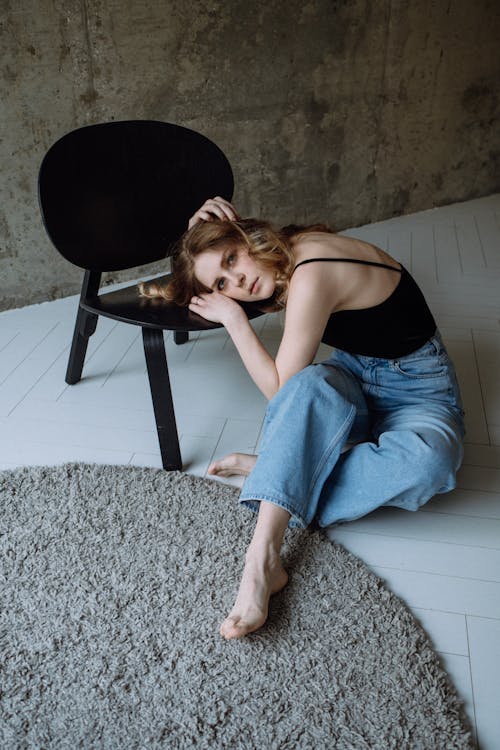 Woman Lying Down on a Black Chair