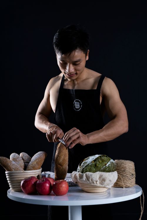 Free Chef slicing artisan bread with apples on table in Hanoi, Vietnam. Stock Photo