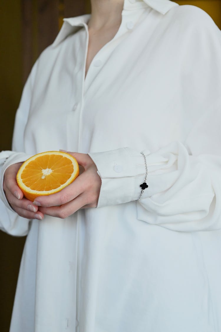 Woman In White Shirt Holding An Orange