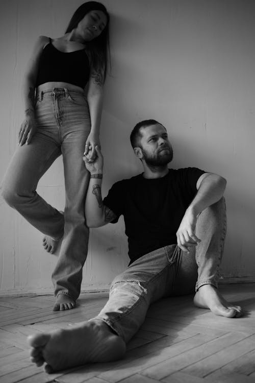 Grayscale Photo of Man and Woman Holding Hands