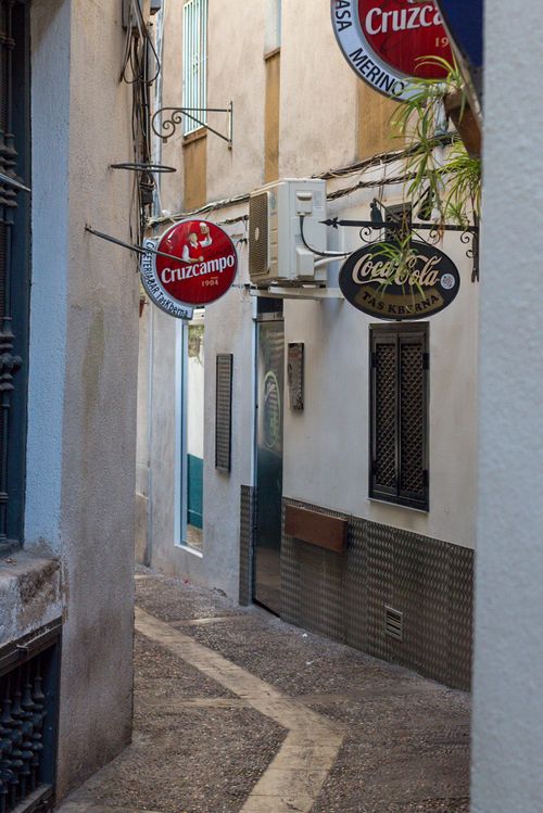 Free Explore a quaint European alley with vintage signs and urban architecture Stock Photo