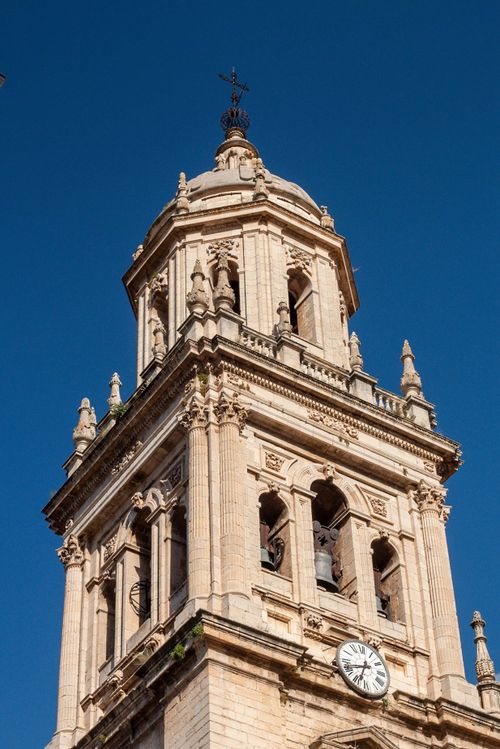 Free Close-up of a historic church tower with clock against a clear blue sky. Stock Photo
