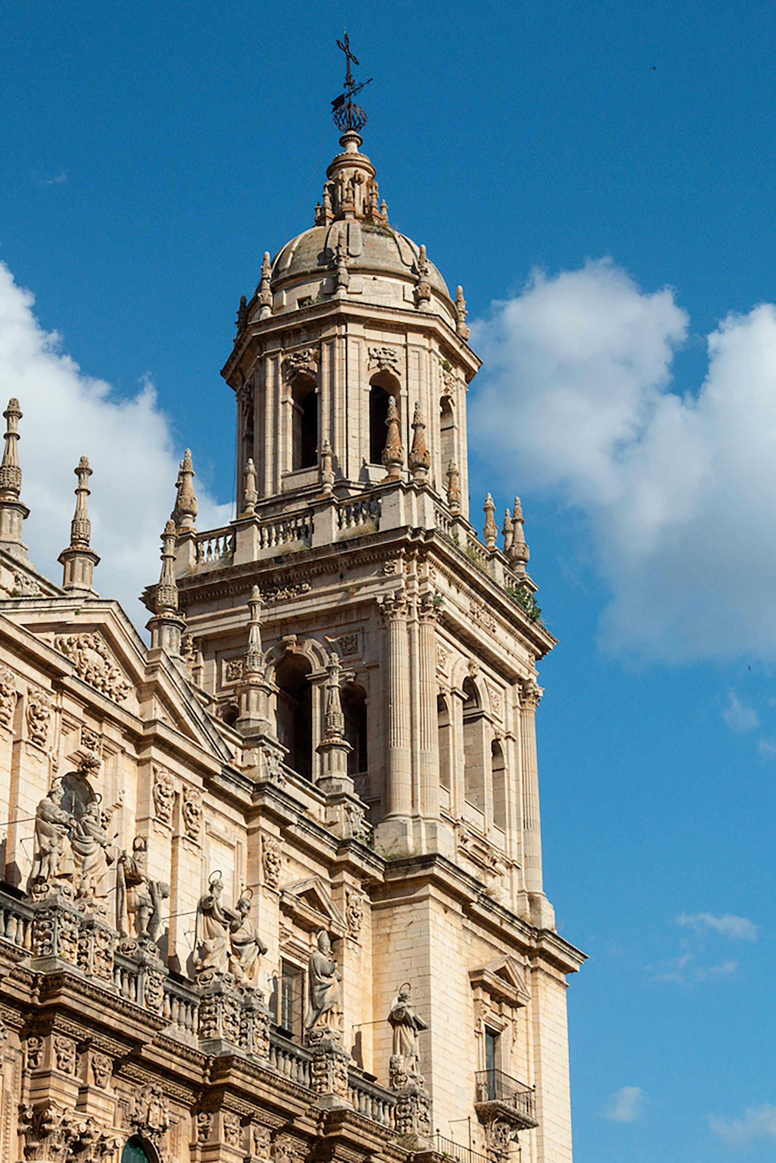 Stunning view of a Renaissance cathedral tower with ornate facade under a clear blue sky.