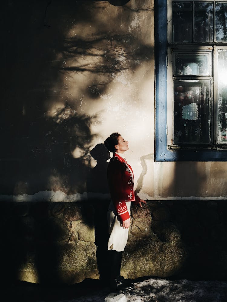 Woman Standing By Old House