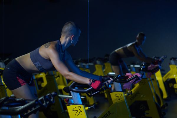Woman riding a stationary studio cycle in a gym