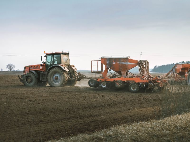 Farm tractors with sowing equipment working a paddock