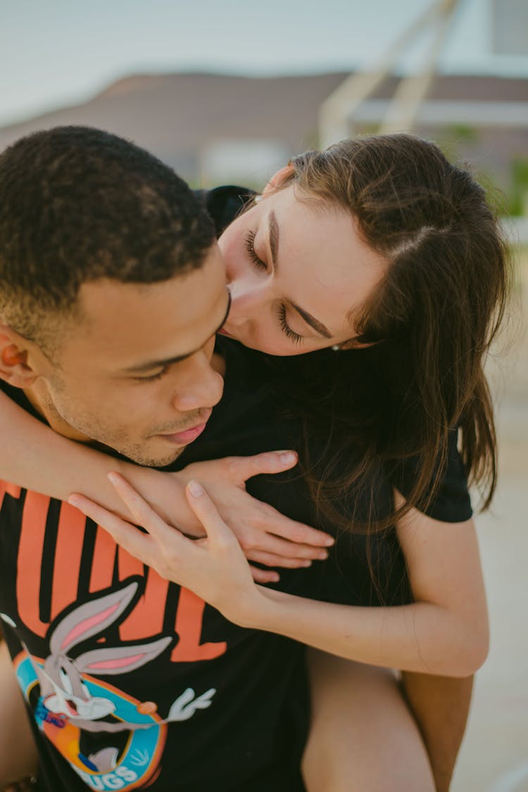 Man Carrying A Woman On His Back And Kisses Him