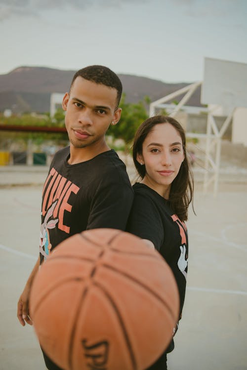 Free Woman in Black and White Crew Neck Shirt Beside Boy in Black and Orange Nike Crew Stock Photo