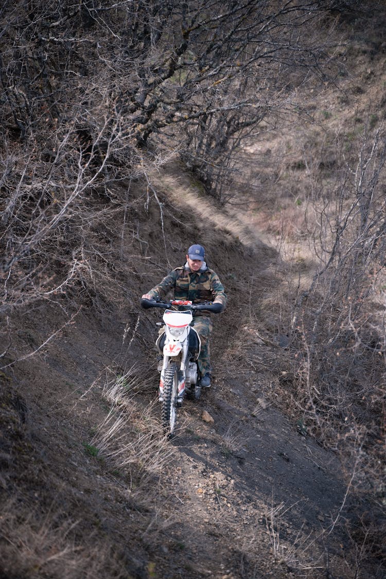 Man On Bicycle Riding Downhill In Forest