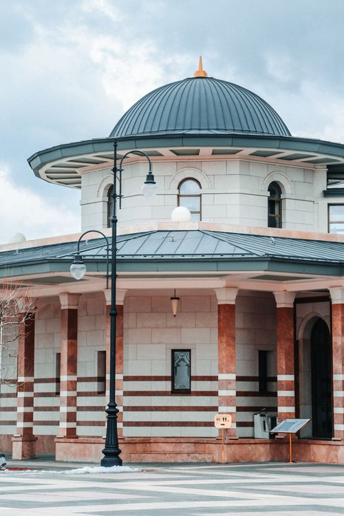 Free A stunning view of a mosque's dome and columns, showcasing Islamic architectural elegance. Stock Photo