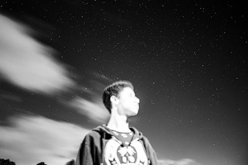 Free Grayscale Photo of Man Standing Under a Starry Sky Stock Photo