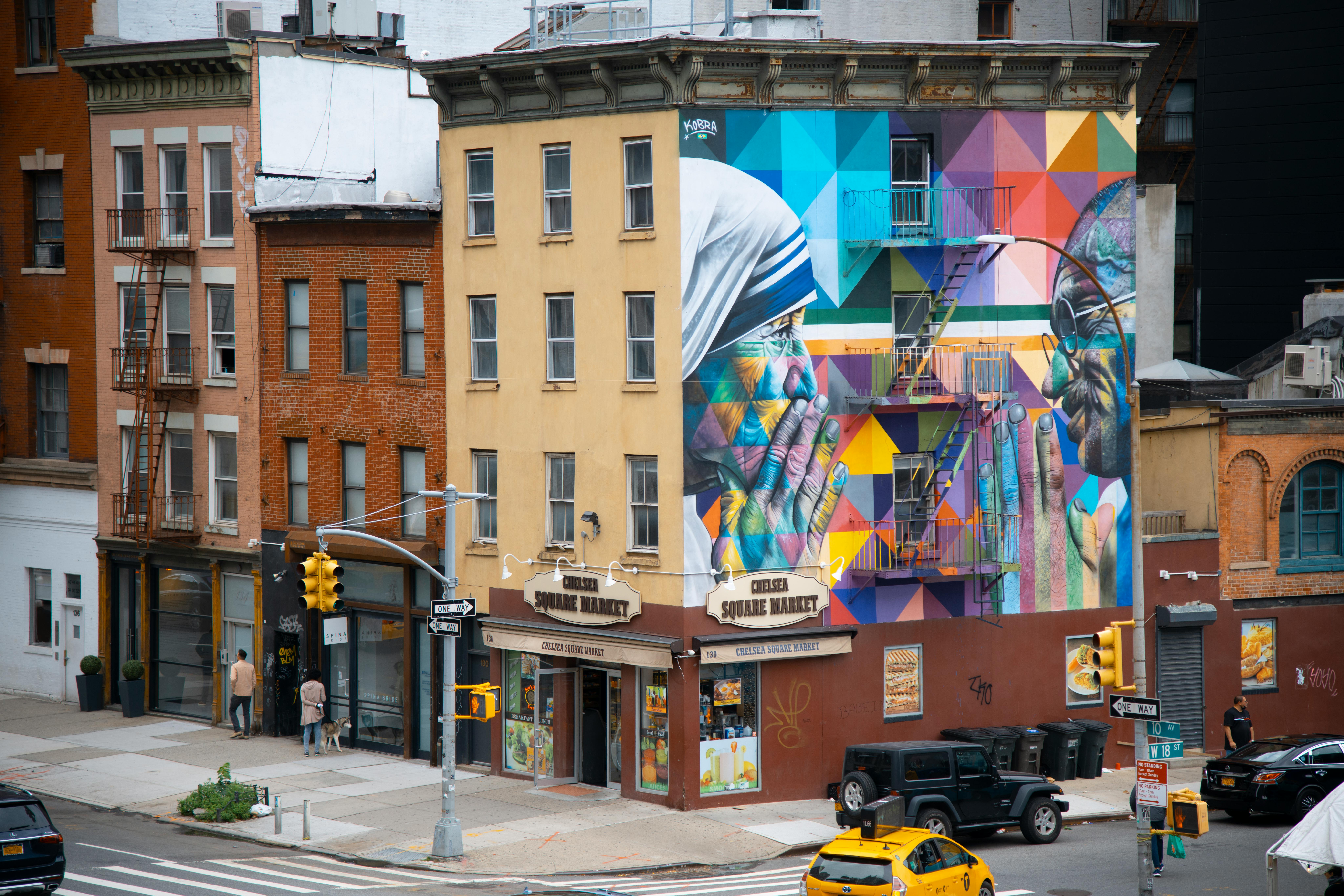 Free Vibrant mural featuring famous figures adorns a New York City building facade in a lively urban setting. Stock Photo