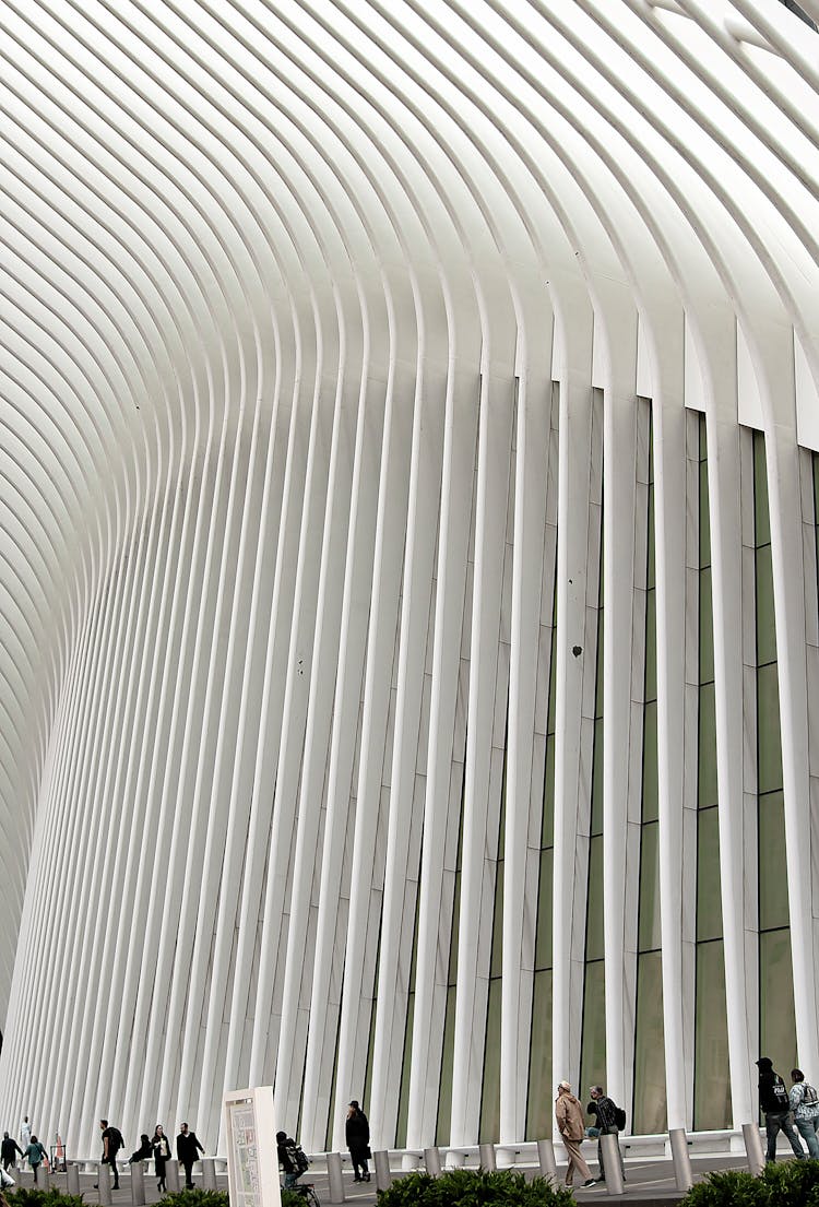 People Walking Near Modern Geometric Building