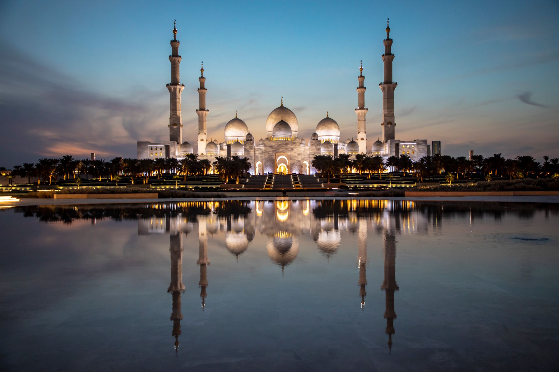 Majestic view of Sheikh Zayed Grand Mosque reflecting in the water at dusk, Abu Dhabi, UAE.