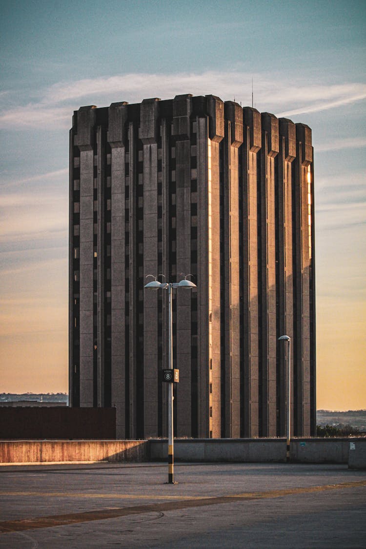 Residential Building Seen From Empty Parking Lot At Sunset