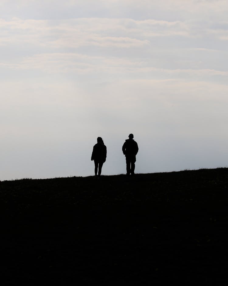 Man And Woman Walking Under Clouds