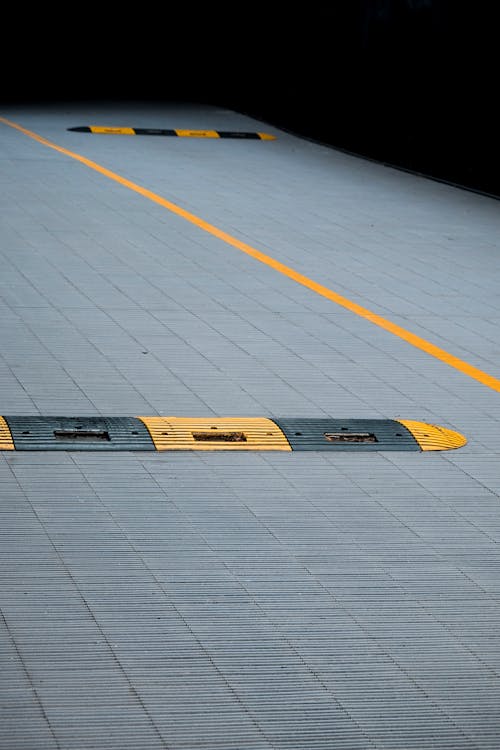 Yellow and Black Plastic Humps on Gray Concrete Floor