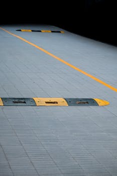 灰色城市人行道上，黄黑相间的减速带清晰标出了停车区