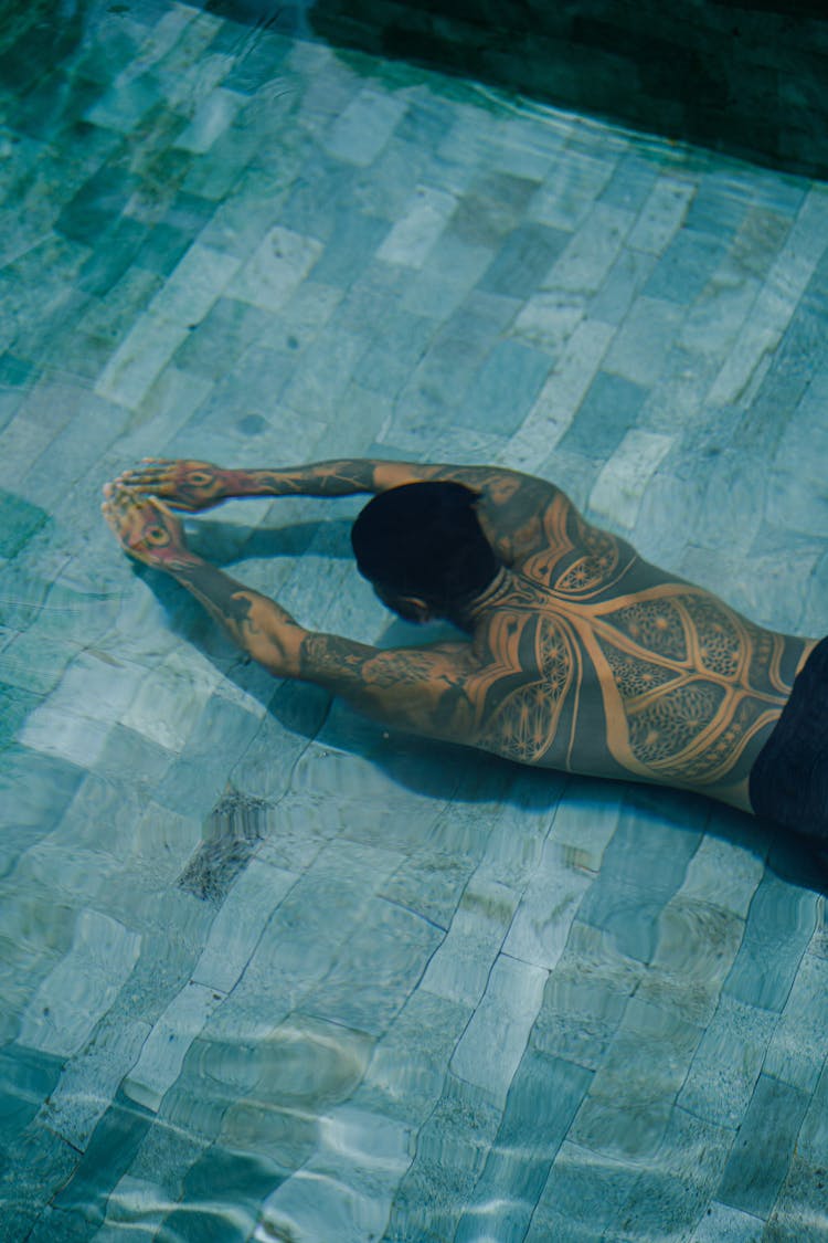 Unrecognizable Tattooed Man Diving In Pool