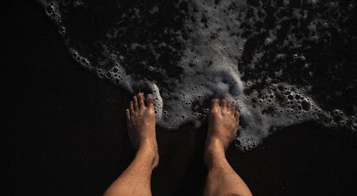 Man Standing in Barefoot on the Shore 