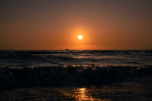 Free A stunning sunset over the ocean, capturing the beauty of nature's calm evening. Stock Photo