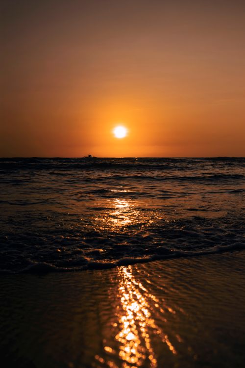 Free Golden sunset over ocean waves with reflections on the water, creating a serene and scenic seascape. Stock Photo