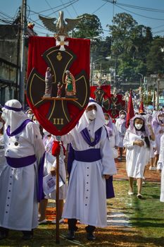 A vibrant religious procession with participants in traditional attire and masks.