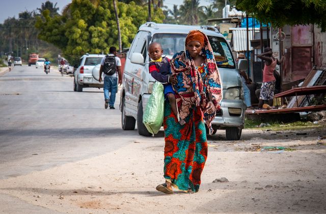 A mother and child walk together in a vibrant street scene in Zanzibar, Tanzania. — arriving in Zanzibar