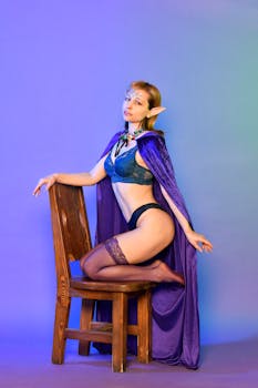 Elegant fantasy-themed portrait of a woman dressed as an elf in lingerie and a cape.
