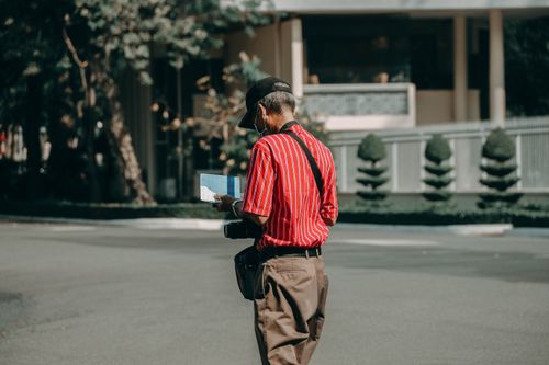 Free An elderly man with a camera and face mask exploring the streets of Vietnam. Stock Photo