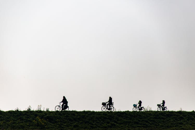 Silhouette Of A Family Riding Bicycles