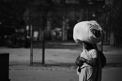 Grayscale Photo of a Woman with a Bag on Her Head