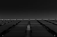 从低角度拍摄的黑白高层建筑，呈现出戏剧性的几何图案