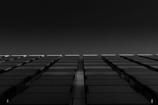 从低角度拍摄的黑白高层建筑，呈现出戏剧性的几何图案