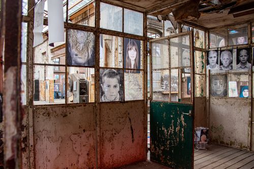 Free Artistic portraits display in an abandoned industrial setting, creating a striking contrast. Stock Photo