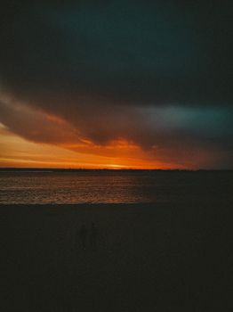 Beautiful sunset scene with dramatic clouds over a calm ocean, perfect for serene and peaceful themes.
