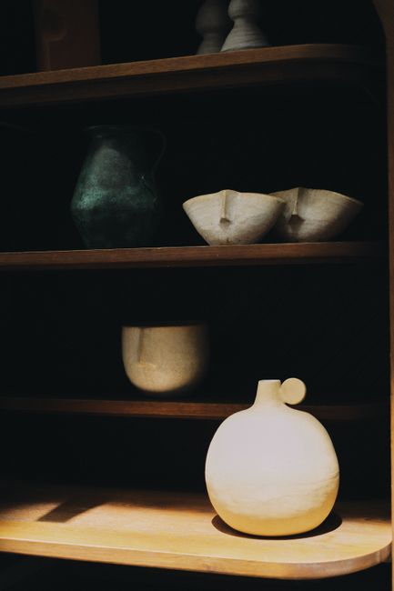 Elegant boho-style ceramics displayed on wooden shelves, perfect for home decor inspiration.
