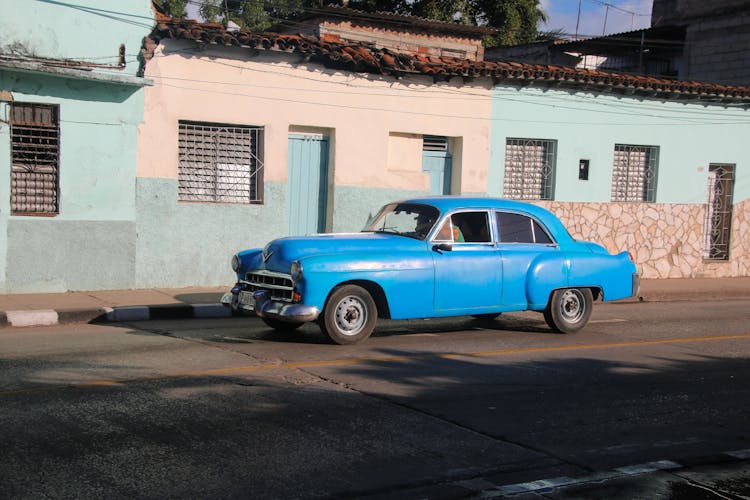 A Blue Vintage Car On The Road