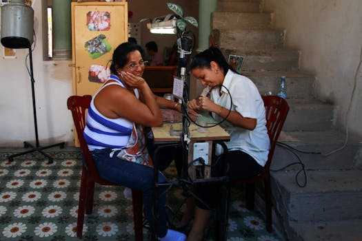 A smiling woman enjoys a manicure in a cozy, indoor nail salon setting. Bright atmosphere.