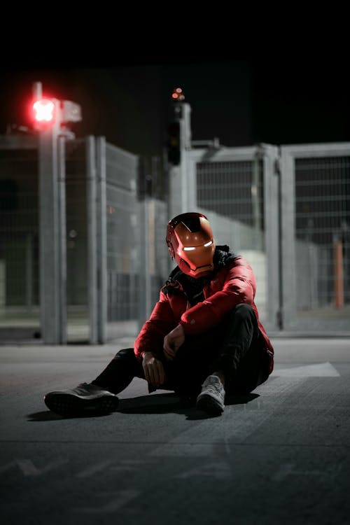 Person in Superhero Cosplay Sitting on Ground