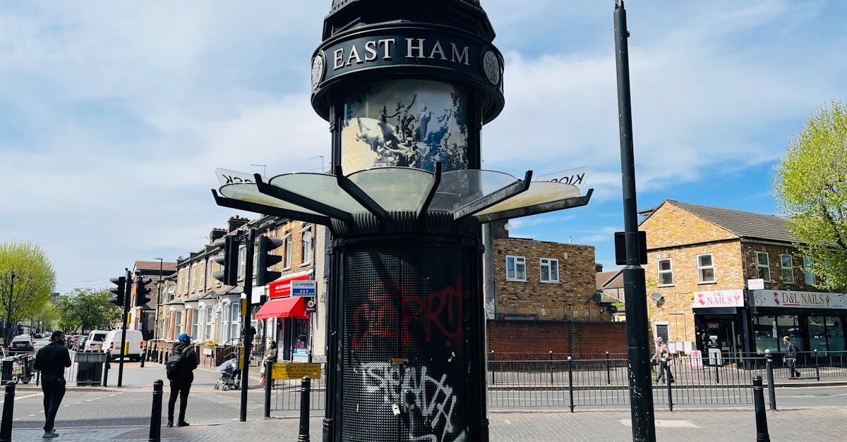 Street view of East Ham, London featuring a historic pavilion with urban graffiti on a sunny day.