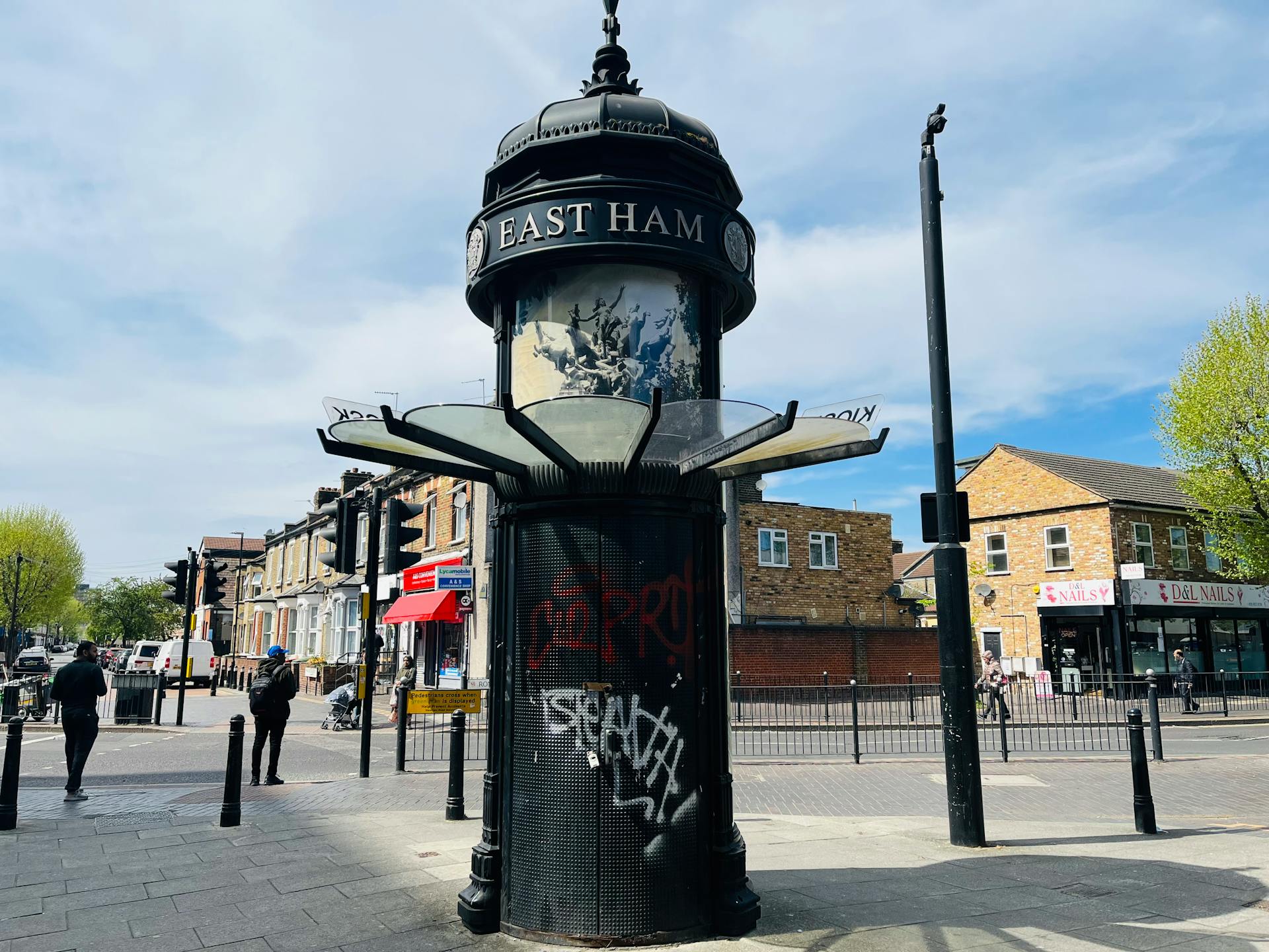 Street view of East Ham, London featuring a historic pavilion with urban graffiti on a sunny day.