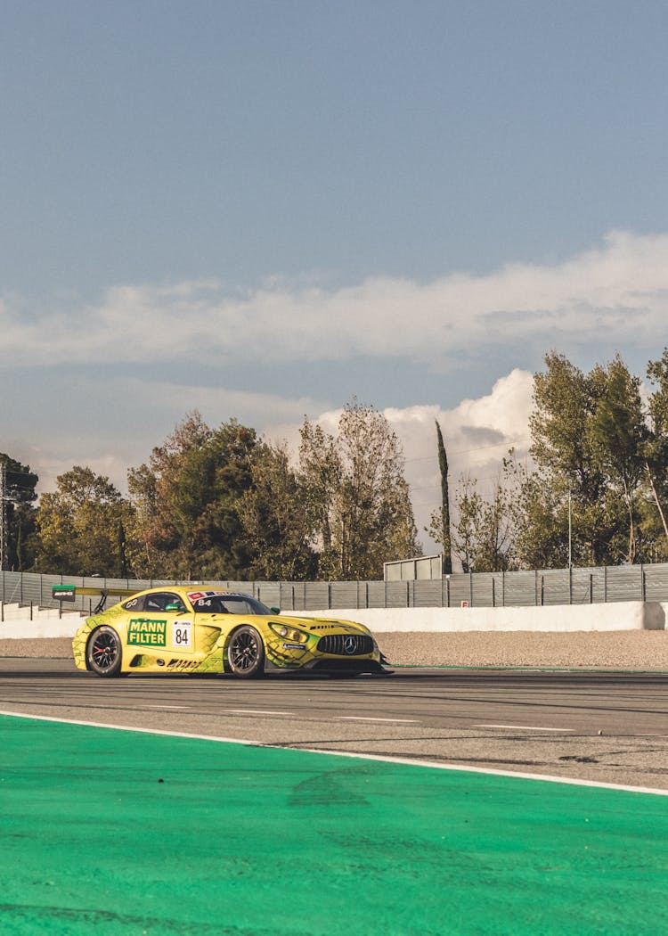 Photo Of A Yellow Racecar On A Racetrack