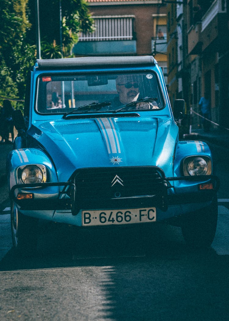 A Man Driving A Blue Car